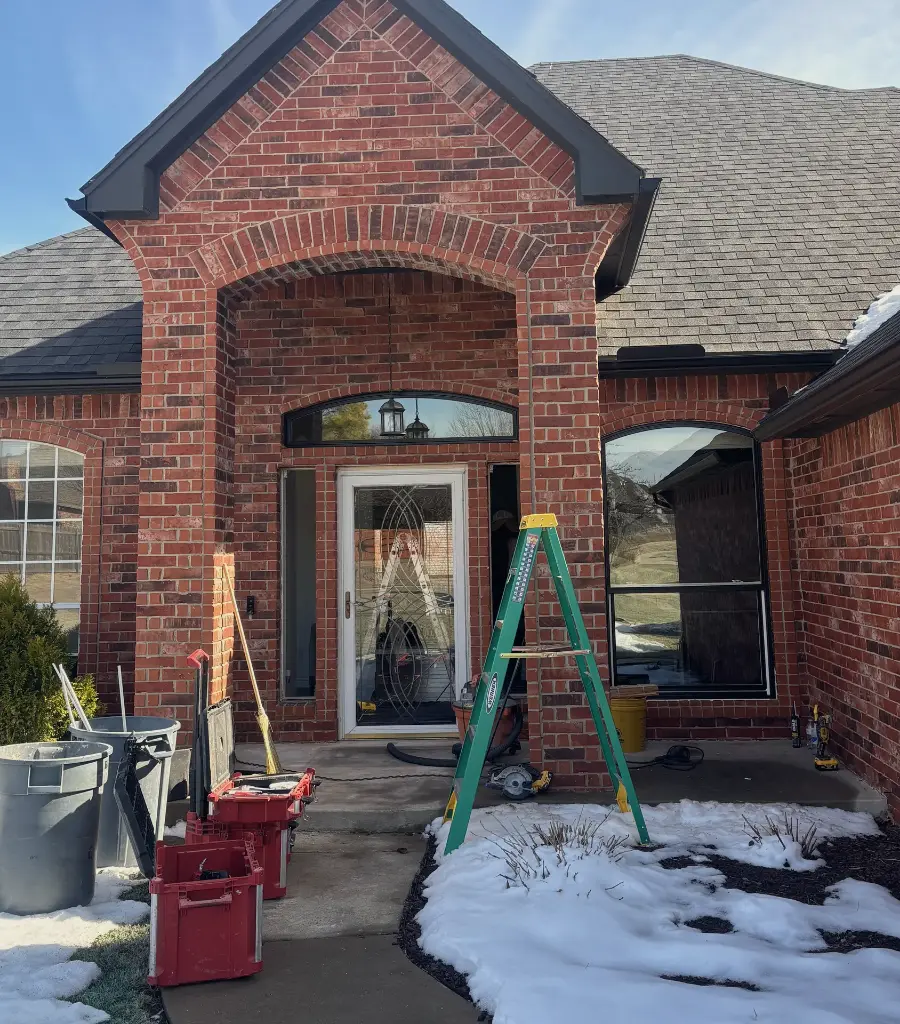 A brick entry before the job, with an old white front door with leaded glass and tools on the walk