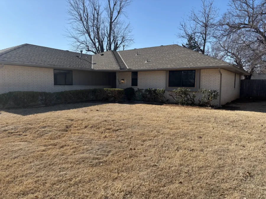 New dark-framed windows across the front of a cream brick house